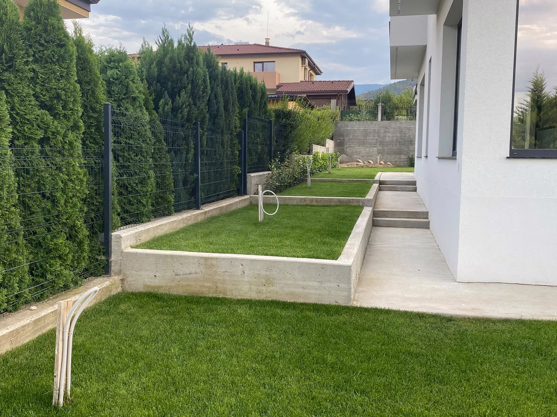 Jardín aterrazado junto a una casa blanca
